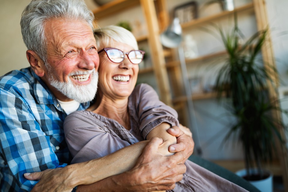 Happy Elderly Couple Hugging on Couch